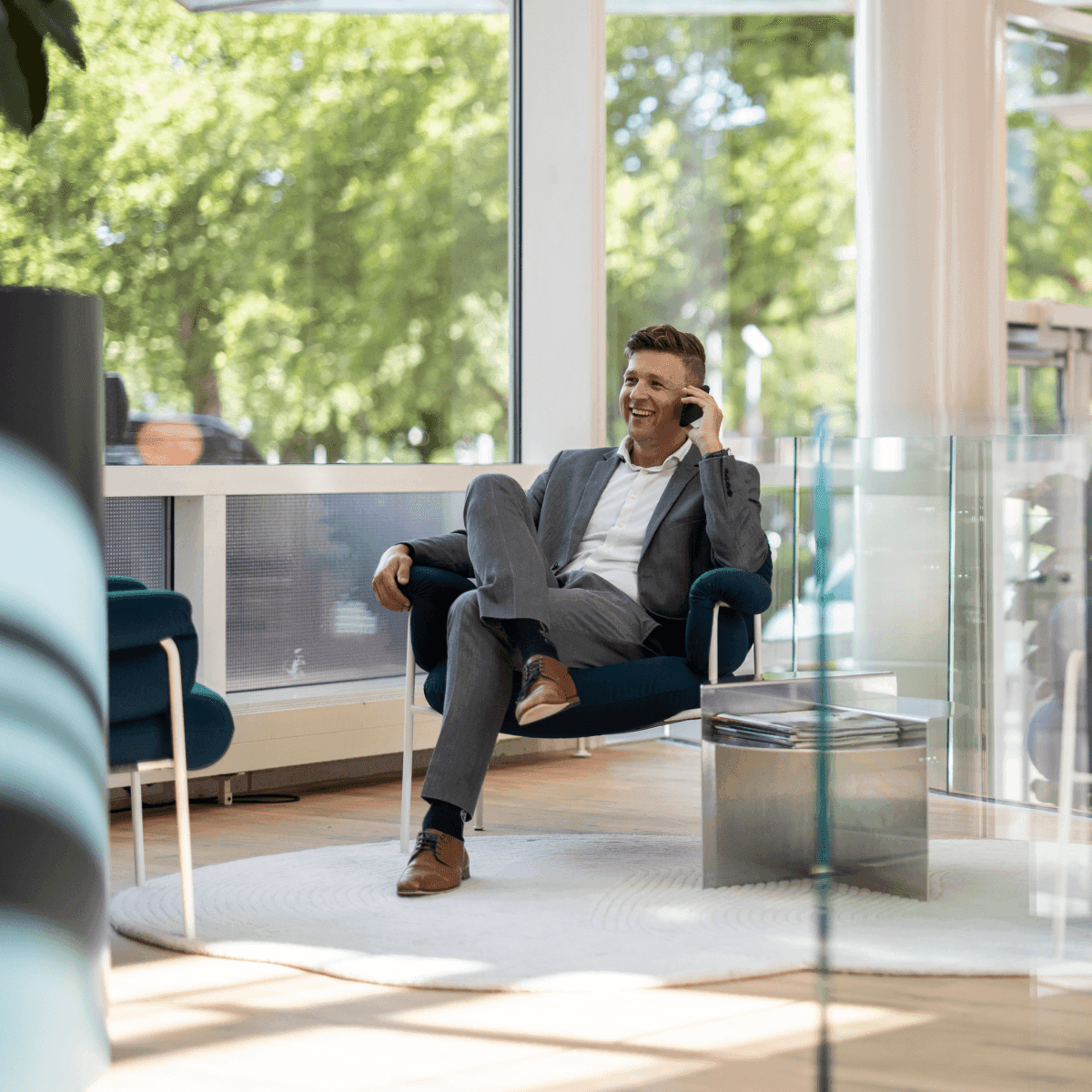 Businessman in grey suit phone call in modern lounge corner