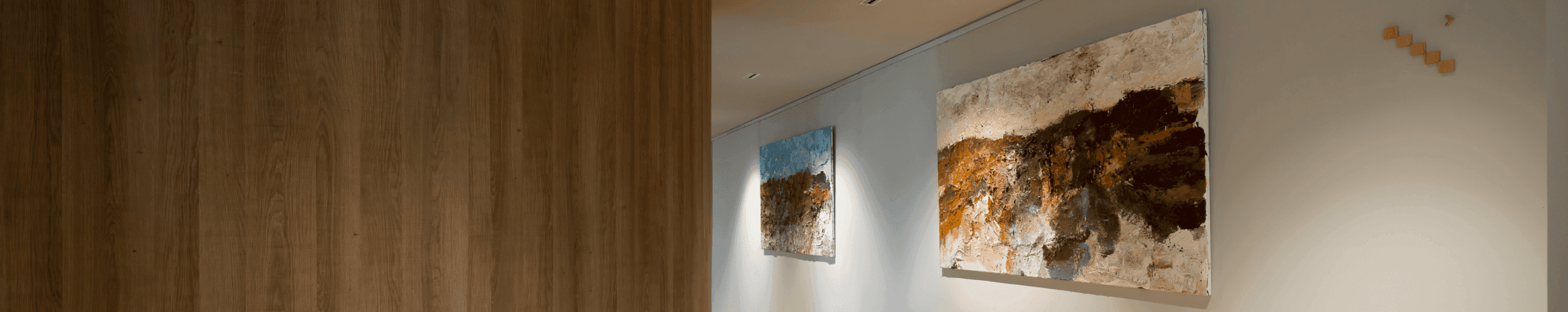 Gang met houten vloer en twee kunstschilderijen