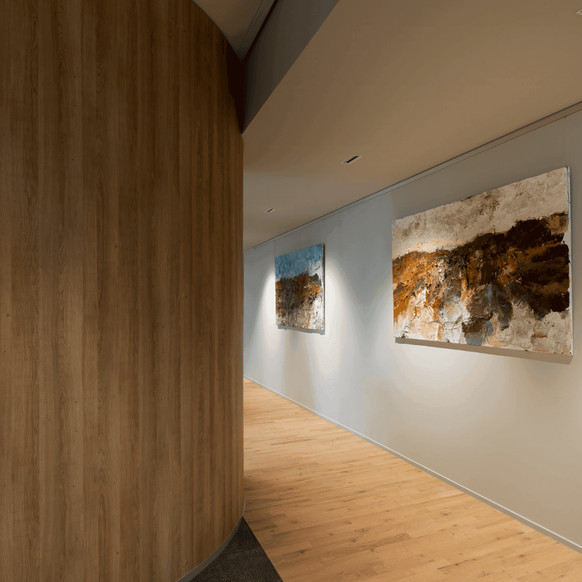 Hallway with wooden floor and two art paintings