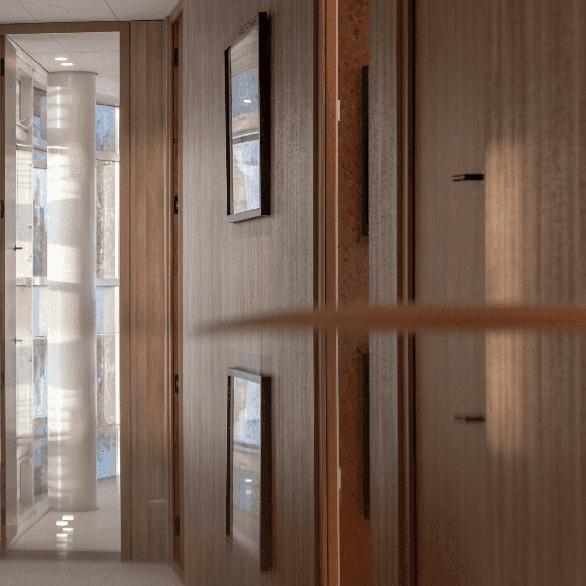 Houten gang met spiegelende oppervlakken en ingelijste kunstwerken