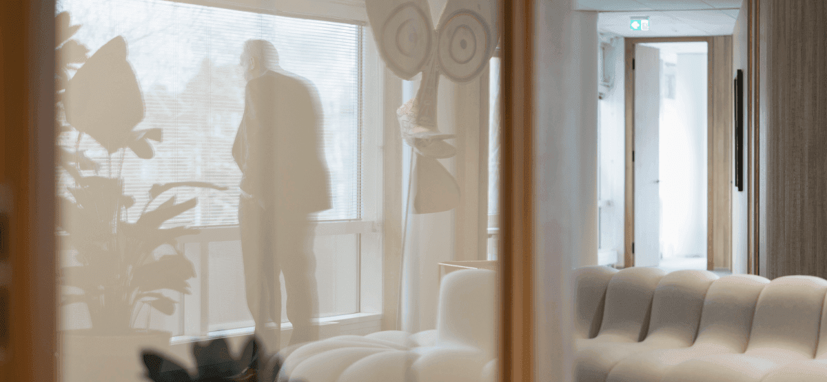 Man standing by window with reflection in office space