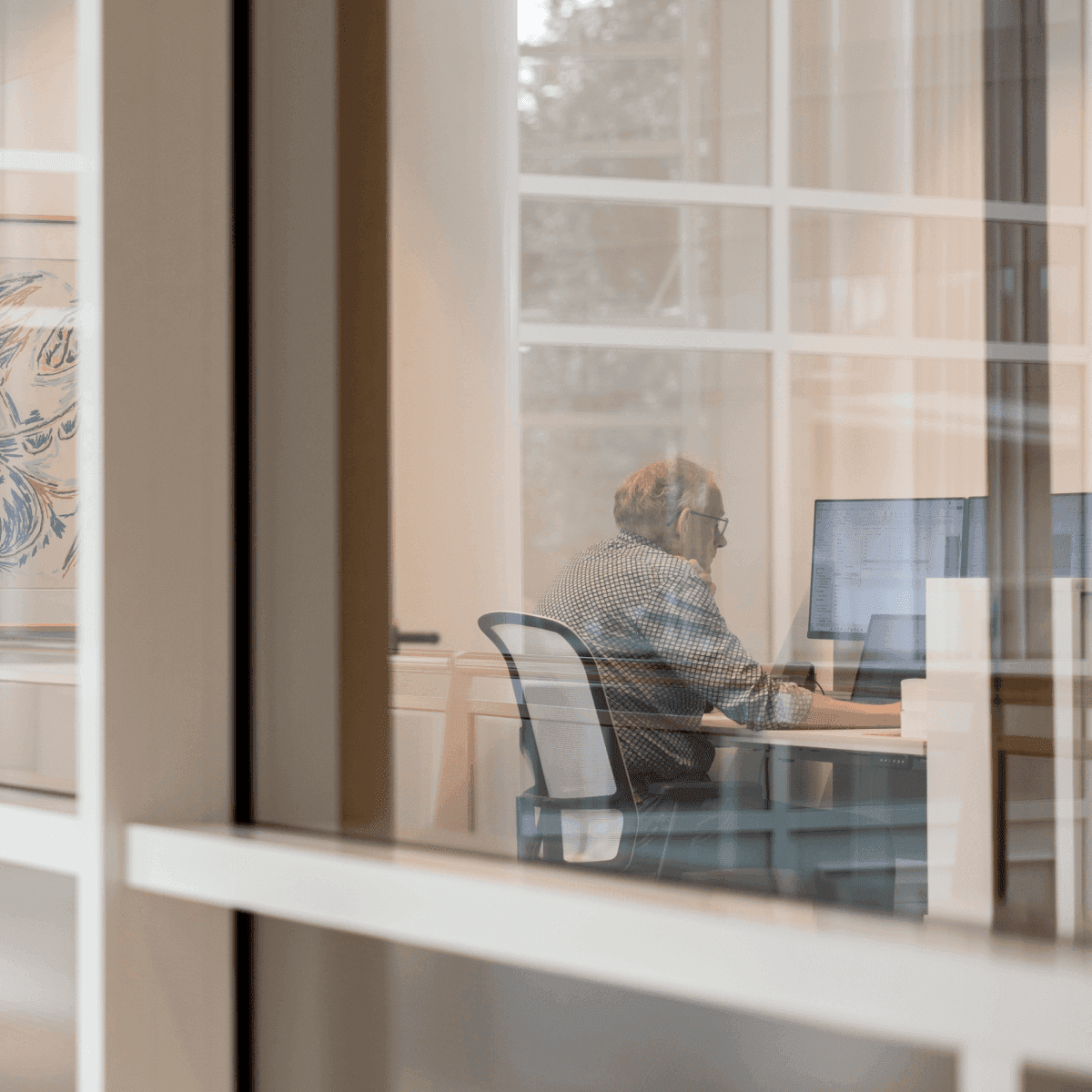 Medewerker achter computer kantoorruimte