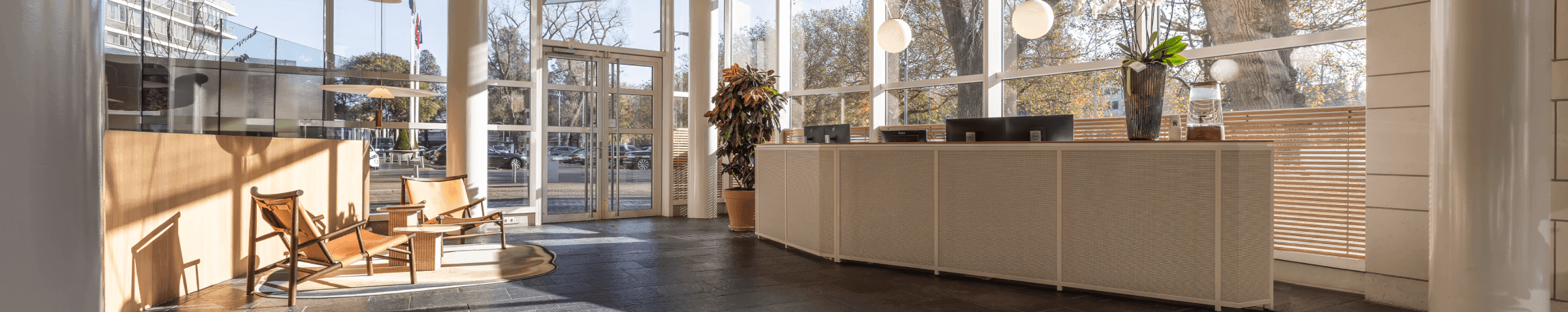 Moderne receptie met grote ramen en houten stoelen