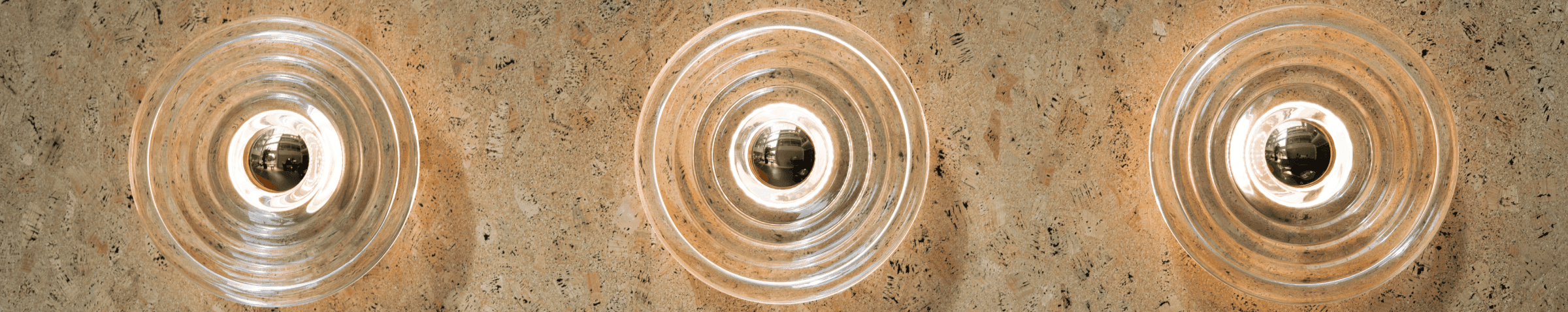 Round modern wall lamp with light reflections on cork