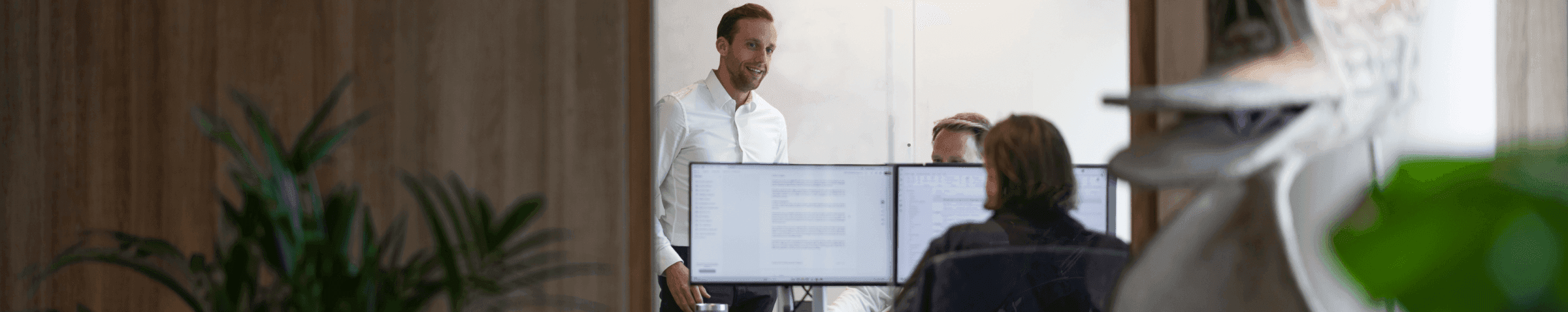 Vergaderende collega’s met laptops in kantoorruimte