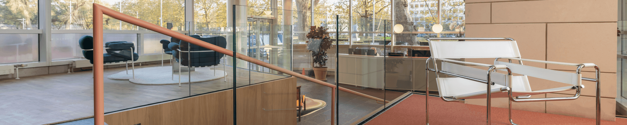 Witte designstoel op oranje vloerkleed in moderne loungehoek