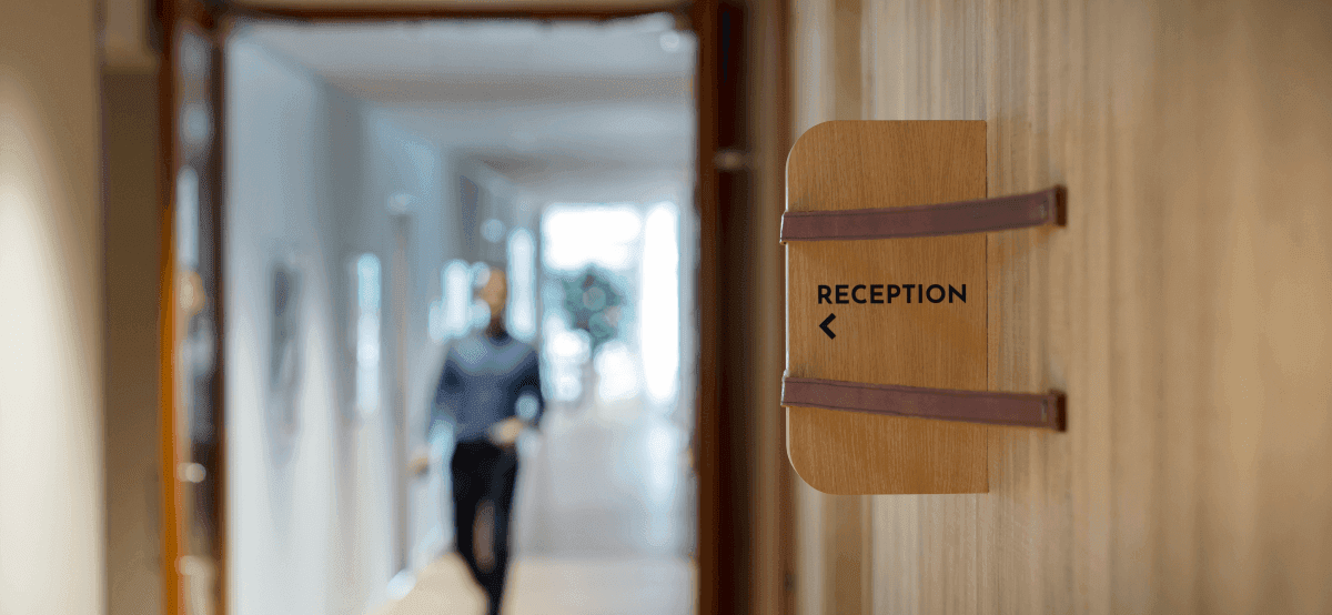 Wooden sign with reception text in hallway